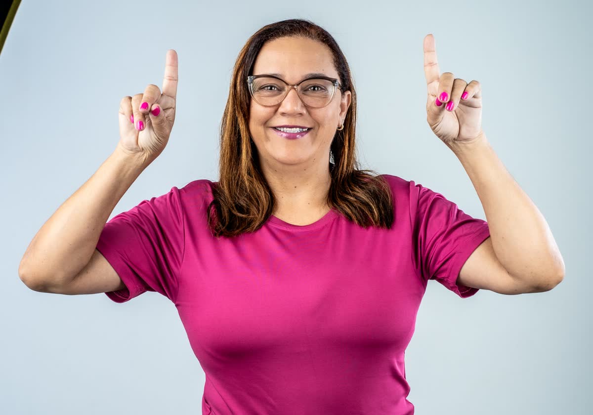 Cristiane Moura sorrindo, vestindo blusa rosa