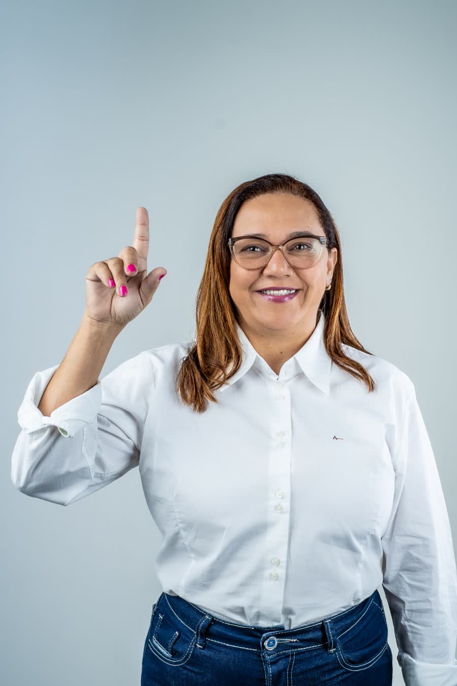 Cristiane Moura sorrindo e apontando para cima